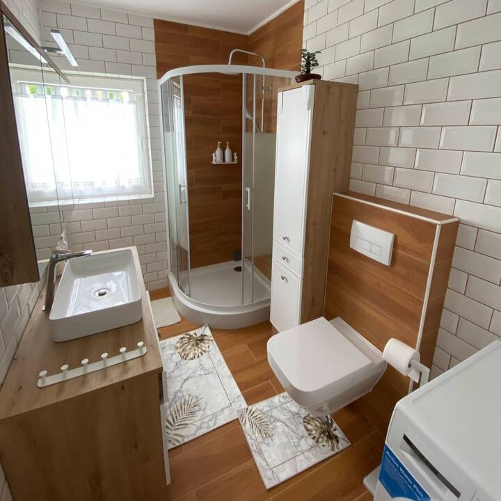 Łazienka z toaletą, prysznicem i pralką